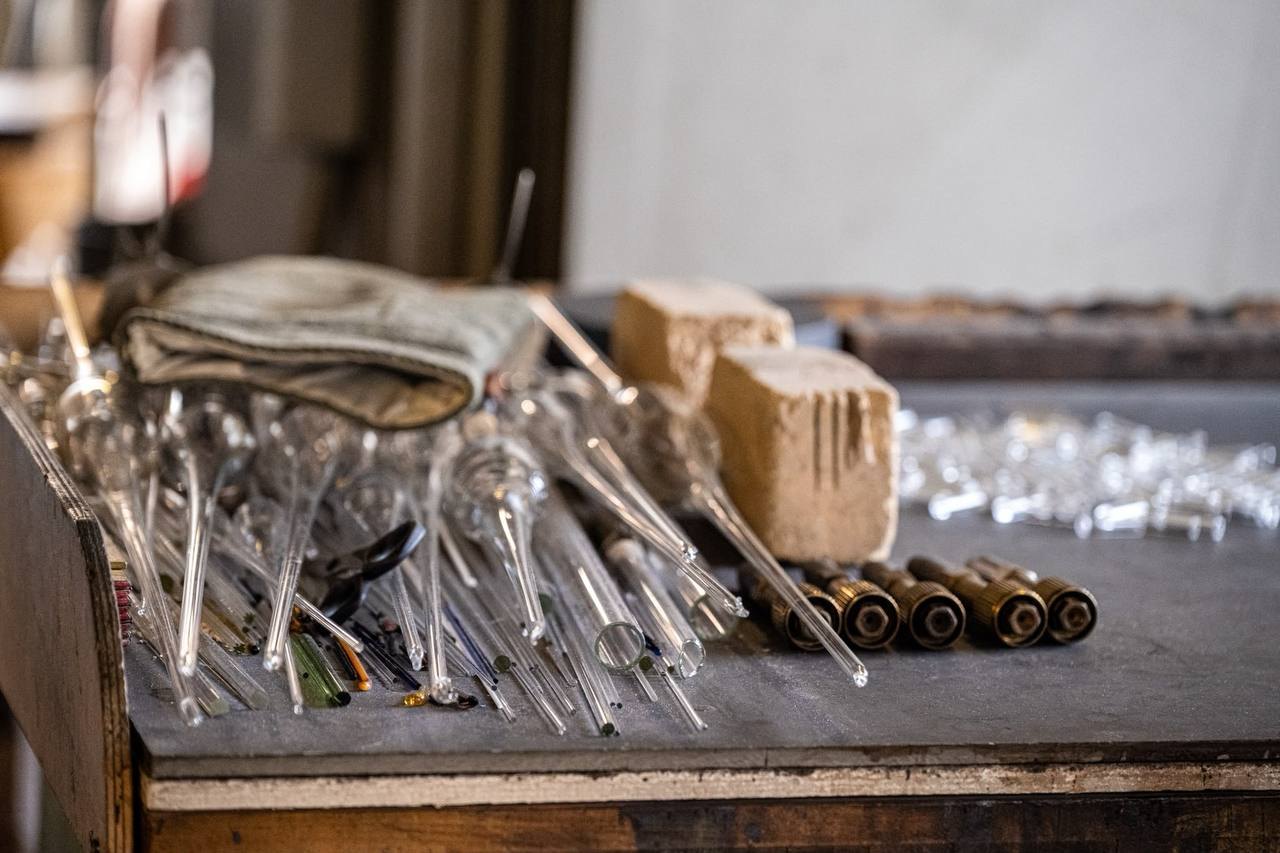 Werkbank mit Glasrohren, Handschuh und Werkzeug am Brennerplatz